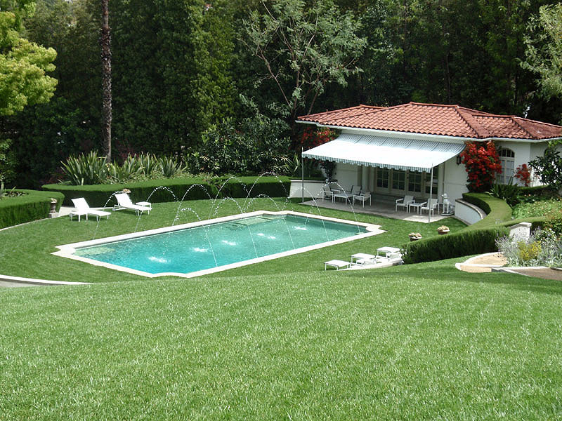 Estate pool house with manicured lawns and fountain jets